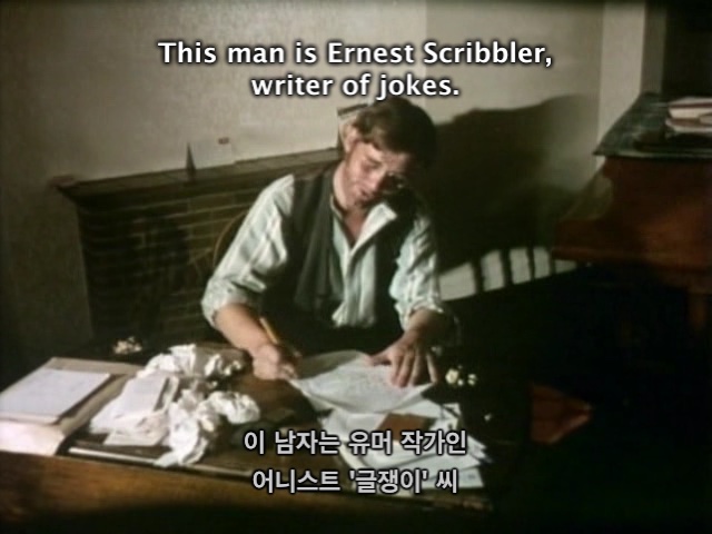 Still of the "deadliest joke" sketch of Monty Python showing the "This man is Ernest Scribbler, writer of jokes" subtitles in English and Korean
