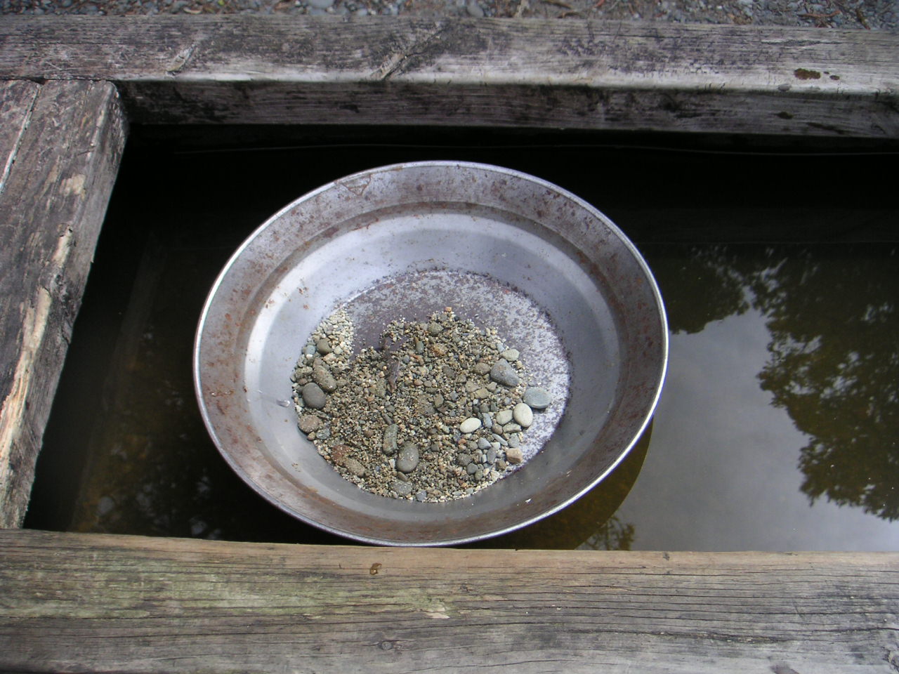 Sifting for gold in a pan full of rubble
