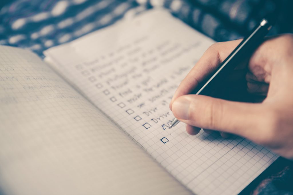 Person ticking boxes on a todo list
