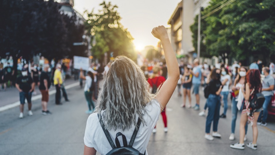 A demonstration in the street with a protester having their hand raised