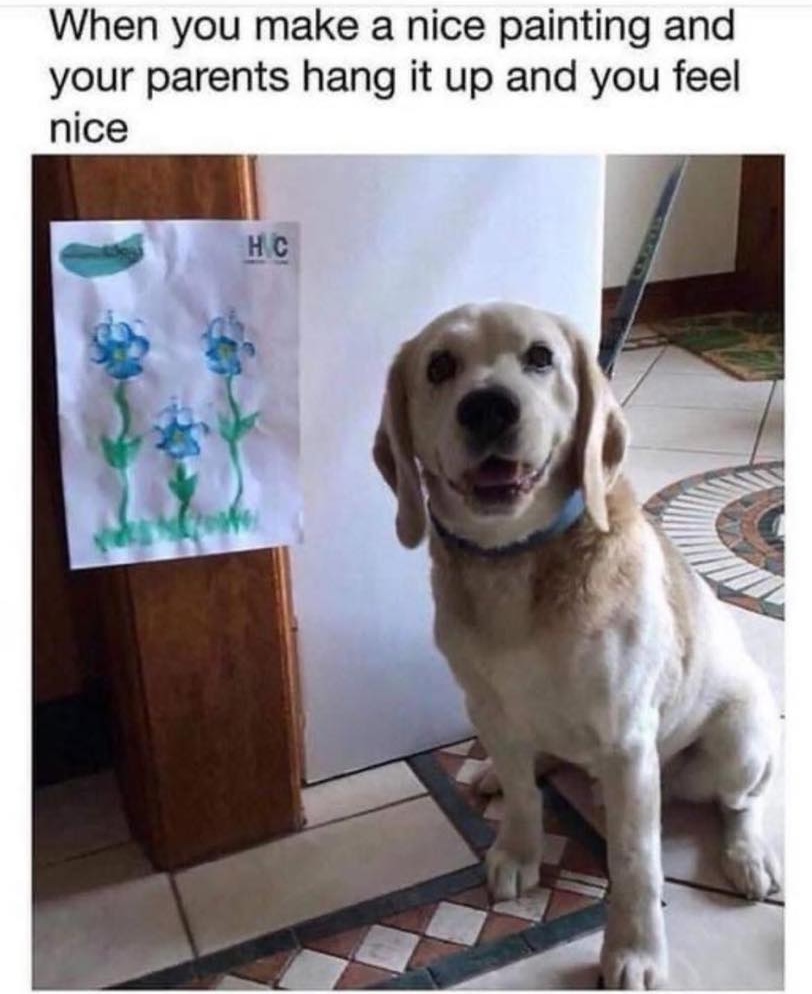 A happy Labrador sitting seemingly smugly in front of a picture that was done by putting its paws in paint with the caption 'When you make a nice painting and your parents hang it up and you feel nice'