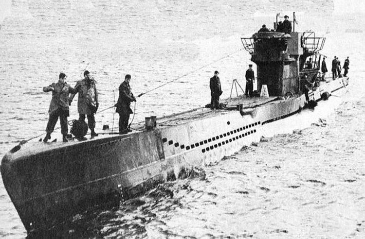 A photo of the German Submarine U 1206, on the sea with 5 people on deck.
